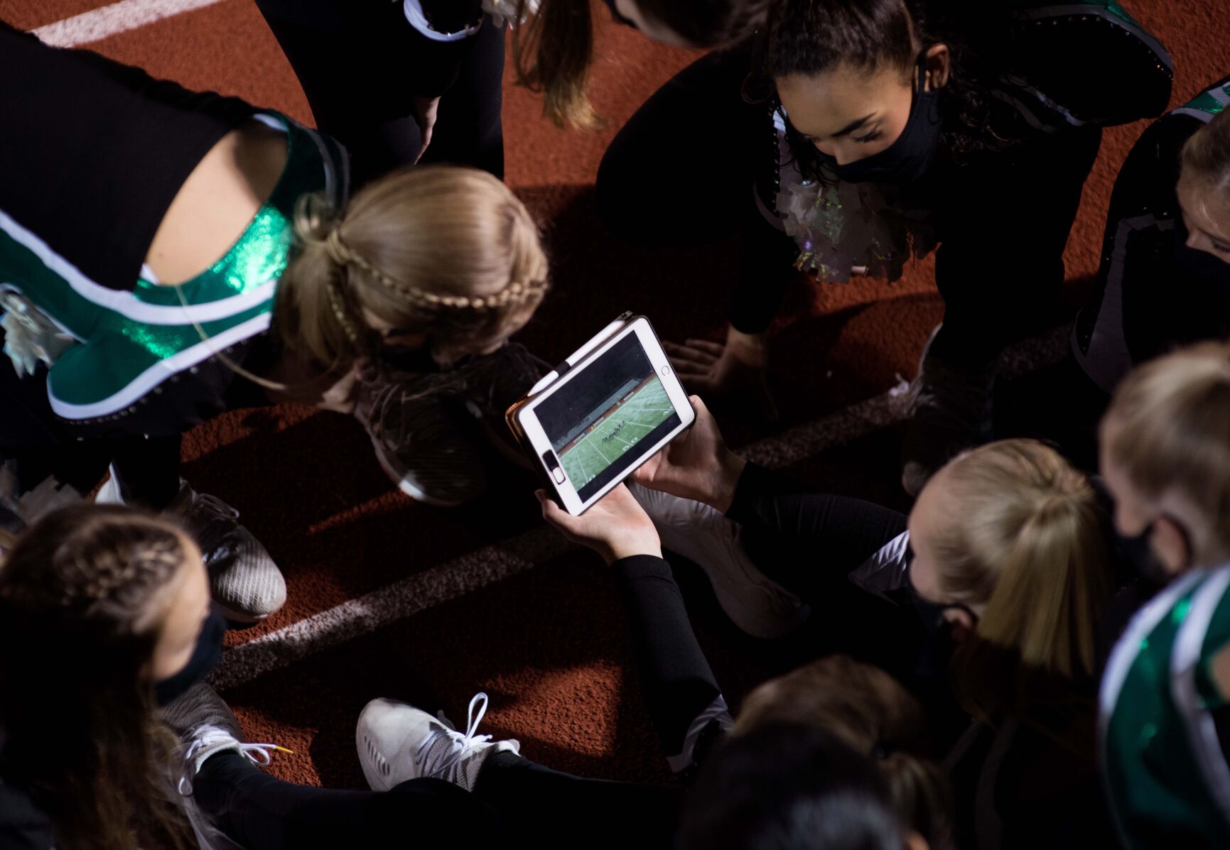 The Rock Bridge dance team watches their halftime routine highlights on a tablet